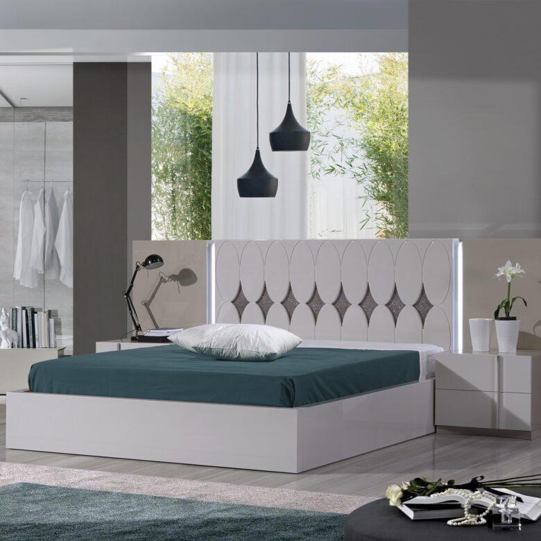 Quarto moderno com cama e luminárias pendentes.